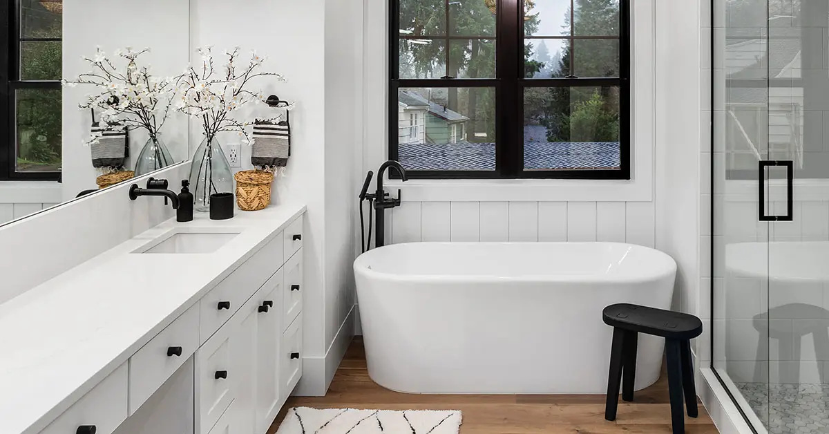 Remodeled bathroom with white cabinets and black fixtures