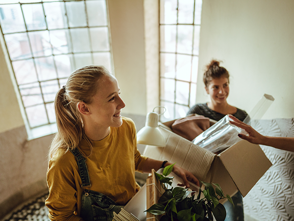 Two young adult women moving into college dorm